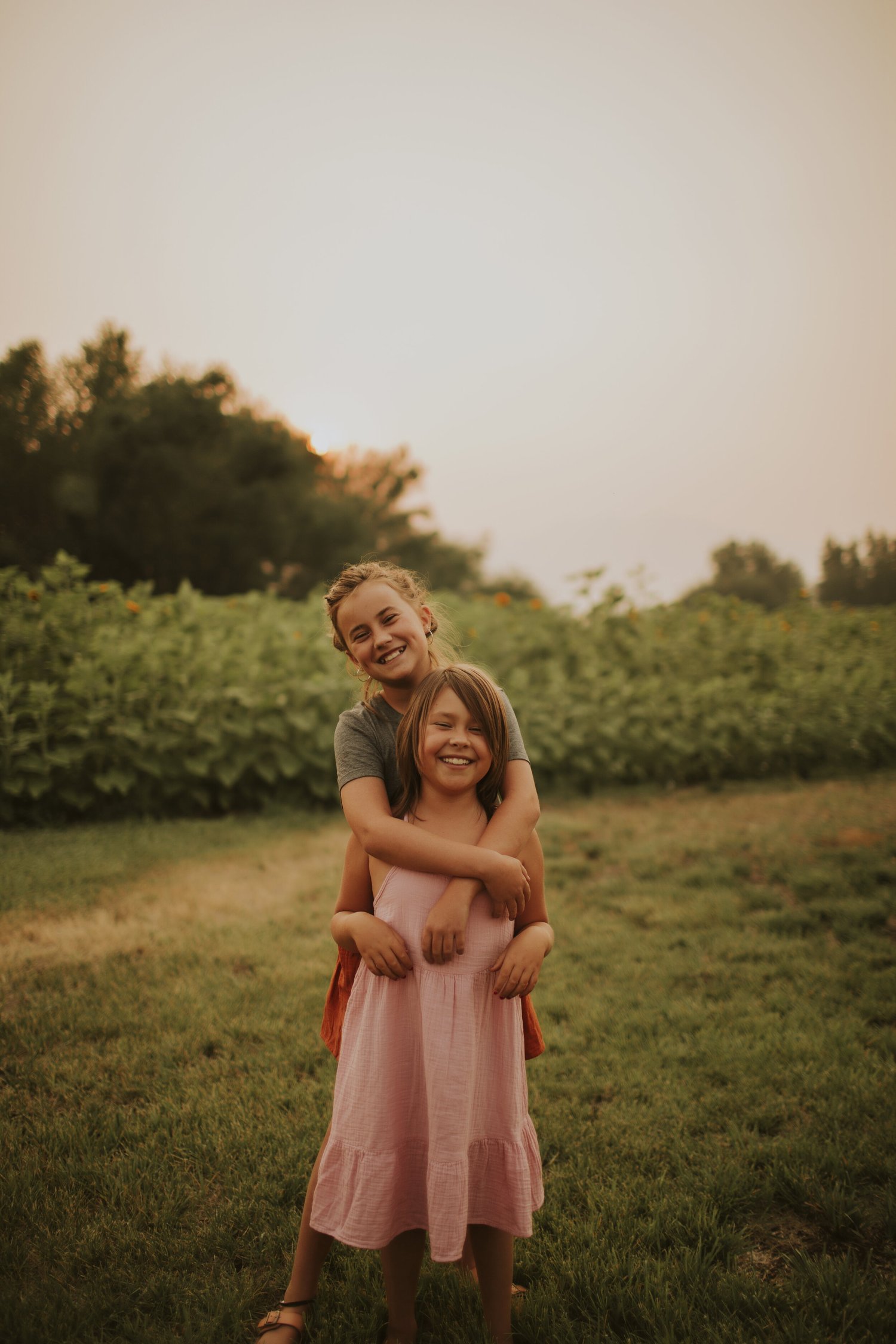 Maddie and Ella laughing in front of the sunflowers